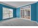 Home office featuring plush carpet, blue walls, and French doors to the dining room at 709 Basil Dr, Durham, NC 27713