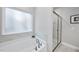 Bright bathroom featuring a soaking tub with marble surround and glass-enclosed shower at 7218 Sunrise Rd, Chapel Hill, NC 27514