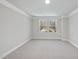 Bright bedroom featuring neutral carpet, crown molding, and large windows offering scenic outdoor views at 7218 Sunrise Rd, Chapel Hill, NC 27514
