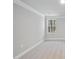 Bright bedroom featuring neutral carpet, crown molding, and a single large window at 7218 Sunrise Rd, Chapel Hill, NC 27514