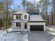 Charming two-story home with a black garage door, inviting front porch and landscaped yard at 7218 Sunrise Rd, Chapel Hill, NC 27514