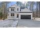 Charming two-story home with a black garage door, white siding, and a welcoming front porch and driveway at 7218 Sunrise Rd, Chapel Hill, NC 27514