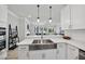 Bright kitchen featuring white cabinets, a farmhouse sink, and seamless access to the living area at 7218 Sunrise Rd, Chapel Hill, NC 27514