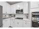 Well-lit kitchen with white cabinets, stainless steel appliances, and elegant countertops at 7218 Sunrise Rd, Chapel Hill, NC 27514