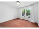 A sunlit bedroom features a large window with white curtains and hardwood floors at 7433 Deer Track Dr, Raleigh, NC 27613