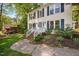 Close-up of a charming home entrance with brick stairs, white railings, and inviting landscaping at 7433 Deer Track Dr, Raleigh, NC 27613