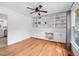 Spacious living room with hardwood floors, ceiling fan, and custom built-in shelving at 7433 Deer Track Dr, Raleigh, NC 27613