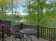 Relaxing outdoor deck overlooking a serene lake, surrounded by lush trees and a comfortable seating area at 8002 Upper Lake Dr, Raleigh, NC 27615