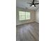 A well-lit bedroom featuring sleek gray flooring and a window showcasing natural light at 8013 River Water Ct, Raleigh, NC 27616