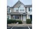 Charming two-story townhome featuring neutral siding, green shrubbery and well-lit entrance at 8013 River Water Ct, Raleigh, NC 27616