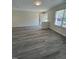Open living room featuring a large window and modern gray flooring at 8013 River Water Ct, Raleigh, NC 27616