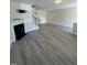 Open-concept living area featuring wood floors, fireplace, and abundant natural light at 8013 River Water Ct, Raleigh, NC 27616