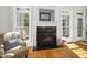Elegant fireplace with detailed trim and large windows, creating a cozy and bright living space at 8480 Falkirk Ridge Ct, Wake Forest, NC 27587