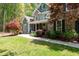 Charming stone and shake siding home featuring a welcoming front porch, meticulous landscaping, and mature trees at 8480 Falkirk Ridge Ct, Wake Forest, NC 27587