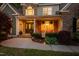 Inviting front porch with stone accents, decorative plants, and comfortable seating area at twilight at 8480 Falkirk Ridge Ct, Wake Forest, NC 27587