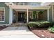 Inviting front porch with stone accents, decorative plants, and comfortable seating area at 8480 Falkirk Ridge Ct, Wake Forest, NC 27587
