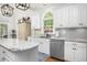 This kitchen has white cabinets, stainless steel appliances and plenty of natural light from the window at 8480 Falkirk Ridge Ct, Wake Forest, NC 27587