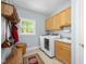 Bright laundry room with modern washer and dryer, storage cabinets, and a utility sink at 8480 Falkirk Ridge Ct, Wake Forest, NC 27587