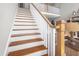 Staircase featuring wood steps, white railings, and a view of the upper level at 8480 Falkirk Ridge Ct, Wake Forest, NC 27587
