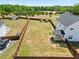 An aerial view displays a well-maintained lawn, fenced yard, covered patio, and driveway with parked cars at 85 Sun Mdw Cir, Benson, NC 27504