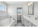 Well-lit bathroom featuring a soaking tub and double vanity with modern fixtures for added convenience at 85 Sun Mdw Cir, Benson, NC 27504