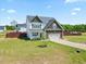 A charming two-story home has a well-manicured lawn, attached garage, and inviting front porch at 85 Sun Mdw Cir, Benson, NC 27504