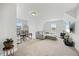 Spacious living room with a gray sectional sofa, desk area, and neutral carpet, creating a versatile and comfortable space at 85 Sun Mdw Cir, Benson, NC 27504