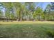 Large grassy backyard with mature trees and a playset is ideal for outdoor fun at 8812 Green Arbor Ct, Wake Forest, NC 27587