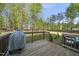 Backyard deck overlooking a grassy area with a grill, wooden railings and stairs leading to the yard at 8812 Green Arbor Ct, Wake Forest, NC 27587