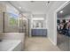 Bright bathroom features dual sinks, a soaking tub, and a separate glass-enclosed shower, perfect for relaxation at 8812 Green Arbor Ct, Wake Forest, NC 27587