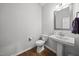 This powder room features a pedestal sink, hardwood flooring, and convenient toilet in a neutral color palette at 8812 Green Arbor Ct, Wake Forest, NC 27587