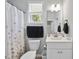 Bathroom featuring a toilet, sink, and a mirror as well as a large window and shower/tub combo at 8812 Green Arbor Ct, Wake Forest, NC 27587