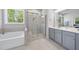 Bright bathroom featuring a walk-in shower, tub and double sink vanity illuminated by large windows at 8812 Green Arbor Ct, Wake Forest, NC 27587