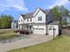 Wide angle of the two story home with 3-car garage and basketball hoop on an expansive driveway at 8812 Green Arbor Ct, Wake Forest, NC 27587