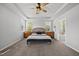 Bright and spacious main bedroom with a tray ceiling, a bed with a wicker headboard, and generous natural light at 8812 Green Arbor Ct, Wake Forest, NC 27587