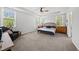 Bright main bedroom with neutral carpet, a tray ceiling, and plenty of natural light from the surrounding windows at 8812 Green Arbor Ct, Wake Forest, NC 27587