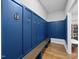 Organized mudroom with blue paneled walls, hooks for coats, and a built-in bench for convenience at 8812 Green Arbor Ct, Wake Forest, NC 27587