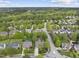 An aerial view of a neighborhood showcasing tree-lined streets, well-maintained homes, and lush green landscaping at 9100 Dansforeshire Way, Wake Forest, NC 27587