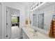 Bright bathroom featuring a white vanity, large mirror, and a view into the adjacent bedroom at 9100 Dansforeshire Way, Wake Forest, NC 27587