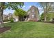 Charming brick home featuring a well-manicured lawn, lush landscaping, and inviting front porch at 9100 Dansforeshire Way, Wake Forest, NC 27587