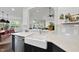 Bright kitchen features a farmhouse sink, stainless steel appliances, and an open view to the living space at 9100 Dansforeshire Way, Wake Forest, NC 27587