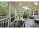 Bright and airy screened porch with a dining table, comfortable seating, and scenic views of the backyard at 9100 Dansforeshire Way, Wake Forest, NC 27587