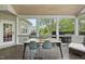 Inviting screened porch with dining area, comfortable seating, and views of the landscaped backyard at 9100 Dansforeshire Way, Wake Forest, NC 27587