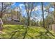 Expansive backyard featuring mature trees, lush grass, and a storage shed beyond the fence at 1008 Holloway St, Durham, NC 27701