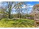 Lush green backyard with mature trees and a wooden fence, offering privacy at 1008 Holloway St, Durham, NC 27701