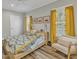 Bright bedroom featuring hardwood floors, large windows with yellow curtains, and modern decor at 1008 Holloway St, Durham, NC 27701