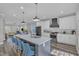 Stylish kitchen with a large center island and barstools, complemented by white cabinets and stainless steel appliances at 1008 Holloway St, Durham, NC 27701