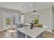 Kitchen island with barstool seating, quartz countertop, and exterior door to backyard at 1008 Holloway St, Durham, NC 27701