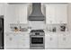 Beautiful kitchen with white cabinetry, stainless steel appliances, and a stylish range hood at 1008 Holloway St, Durham, NC 27701