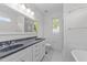 Bathroom featuring dual sinks, soaking tub, walk-in shower, and elegant fixtures and tile at 1011 Parker St, Raleigh, NC 27607